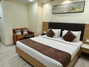 ein Hotelzimmer mit einem großen Bett und einem Stuhl in der Unterkunft Hotel connectzone in Visakhapatnam