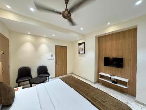 ein Schlafzimmer mit einem großen Bett und zwei Stühlen in der Unterkunft Hotel connectzone in Visakhapatnam