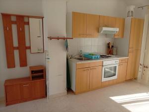 a kitchen with wooden cabinets and a sink and a stove at Dobrila in Slano