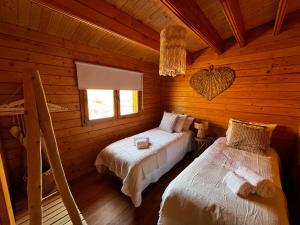 a bedroom with two beds in a log cabin at Corvatos Casas do Monte in Almodôvar +95 photos