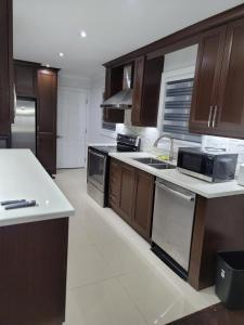 a kitchen with wooden cabinets and a white counter top at Cozy Beautiful Home in Brampton +25 photos