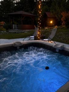 a hot tub in a backyard at night at Guest House Kovačević in Korenica
