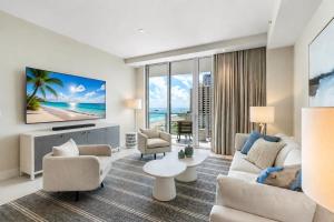 a living room with a couch and a tv at Luxury Ocean View 2BR in Riviera Beach