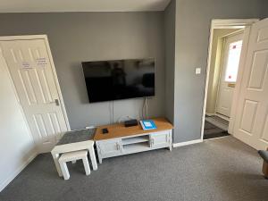 a living room with a table and a tv on the wall at Hinckley Home Leysmill in Hinckley