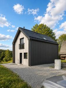 a black and white building with a garage at SenWood House in Zubrzyca Dolna