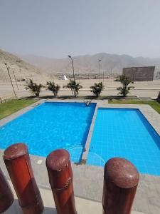 a large blue swimming pool with mountains in the background at Casa Reyna in Hacienda Cienguilla