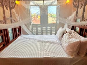 a large bed in a bedroom with a window at Bakarani in Mombasa