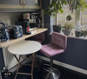 a kitchen with a table and a pink chair at Eastbourne in Pevensey