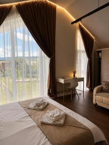 a bedroom with a bed with two towels on it at The NEST Villa in Borşa +72 photos