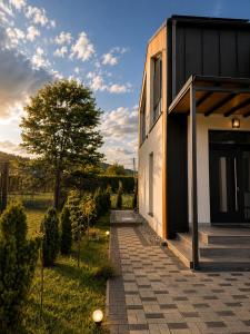 a house with a pathway next to a building at The NEST Villa in Borşa
