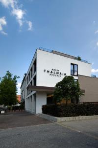 a white building with a sign on the side of it at Hotel Thalmair in Munich