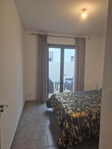 a bedroom with a bed and a sliding glass door at Appartement avec terrasse in Vias