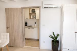 a kitchen with a door leading into a kitchen with white cabinets at Trogir Square Apartment in Trogir