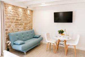 a living room with a blue couch and a table at Trogir Square Apartment in Trogir