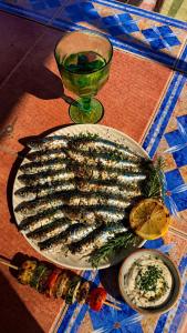 a plate of fish on a table with a drink at La Finca Roja 3 in Coín