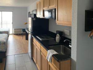 a small kitchen with a sink and a microwave at Studio 6-Lincoln, NE - Airport in Lincoln