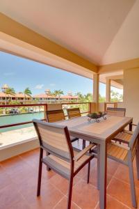 a dining room with a table and chairs on a balcony at Magnificent Belize Townhouse-Pool-Private Island in Placencia