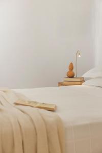 a white bed with a lamp on top of it at Ithaca Garden Villa, Kioni in Kiónion