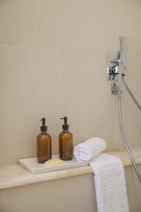 a bathroom with two soap bottles on a shelf at Ithaca Garden Villa, Kioni in Kiónion +42 photos