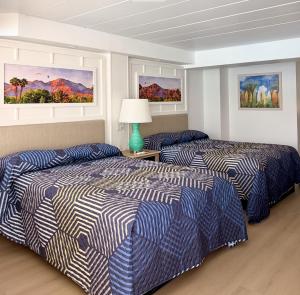 a hotel room with two beds and a lamp at Olympic Island Beach Resort in Wildwood Crest +54 photos
