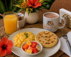 a plate of breakfast food and a cup of coffee at Palaa Mujuii Hotel in Dibulla