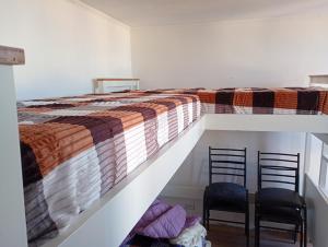 a bedroom with a bunk bed and two chairs at Monoambiente chico in Miramar