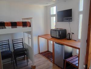 a room with a desk with a microwave and a bunk bed at Monoambiente chico in Miramar