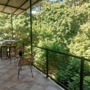 a balcony with chairs and a table and trees at Casa Congo Tamarindo in Villarreal