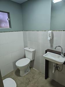 a bathroom with a toilet and a sink at Recanto Grande Lago in Massaranduba +4 photos