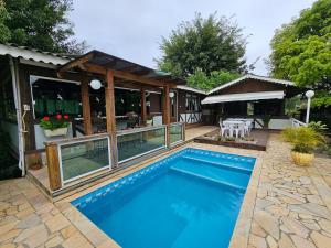 a swimming pool in front of a house at Recanto Grande Lago in Massaranduba
