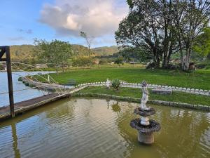 a fountain in the middle of a body of water at Recanto Grande Lago in Massaranduba