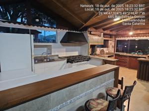 a kitchen with a counter with a sink and a stove at Recanto Grande Lago in Massaranduba