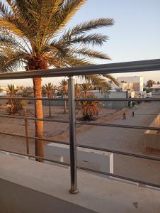 a view of a beach from a balcony with palm trees at اقامة بيرم Résidence Bayrem in Houmt Souk +12 photos