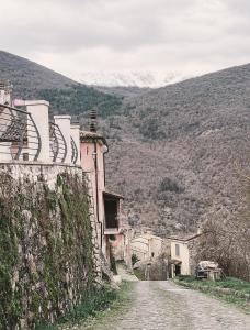 a dirt road next to a building with mountains in the background at Dai Nonni Vacation Home in Acciano
