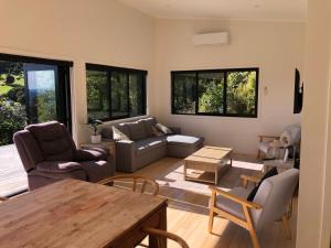 a living room with a couch and a table at Ocean Cliff Court in Kuaotunu