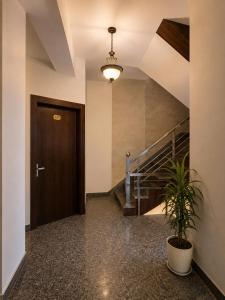 a hallway with a door and a potted plant at hotel urban ade in Tājganj
