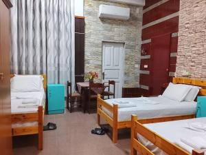 a room with two beds and a table at Guest House Univers in Berat +29 photos