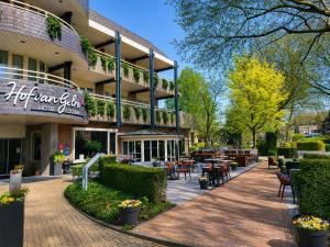 a building with tables and chairs in front of it at Hotel Hof van Gelre by Flow in Lochem