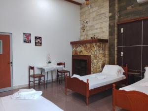 a room with two beds and a fireplace at Guest House Univers in Berat