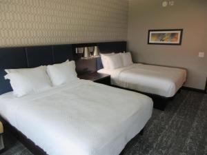 a hotel room with two beds with white sheets at Glo Best Western Olive Branch in Olive Branch +18 photos
