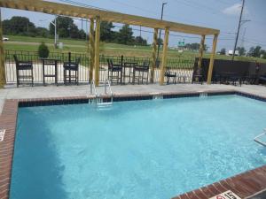 a large swimming pool with chairs and a gazebo at Glo Best Western Olive Branch in Olive Branch