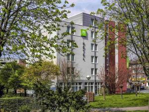 a white building with a green sign on it at ibis Styles Hotel Gelsenkirchen in Gelsenkirchen