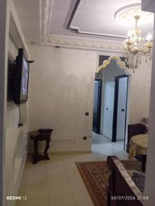 a living room with a television and a mirror at Rez de chaussée in Ifrane +8 photos