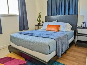 a bedroom with a bed with an orange pillow on it at Pet-Friendly Downtown Kanab Basecamp | Hot Tub in Kanab