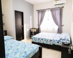 a bedroom with two beds and a window at Hostal Mi Puerto in Puerto Triunfo