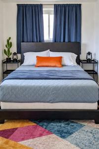 a bed with an orange pillow on top of it at Pet-Friendly Downtown Kanab Basecamp | Hot Tub in Kanab