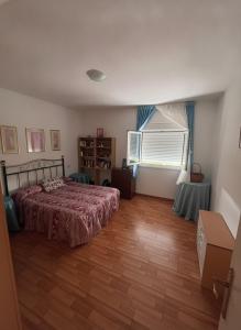 a bedroom with a bed and a wooden floor at Casa Vila in Pol