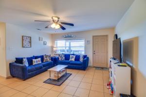 a living room with blue couches and a ceiling fan at 'Sea-King Sol' Ocean-View Condo in Port Aransas! in Port Aransas