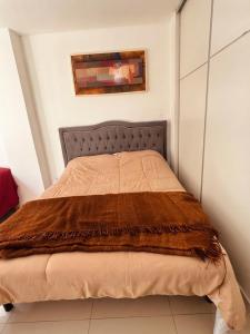a bedroom with a bed with a brown blanket at Moderno dpto céntrico CNH in Santiago del Estero