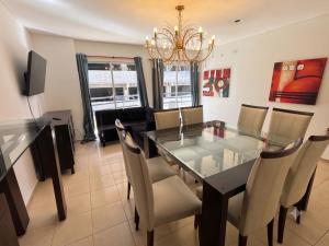 a dining room with a glass table and chairs at Moderno dpto céntrico CNH in Santiago del Estero